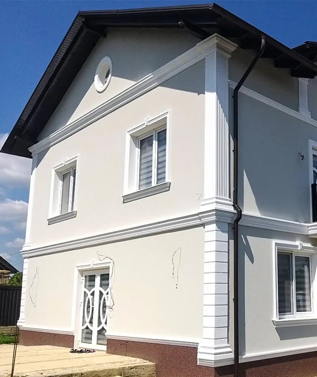 Fațadă de casă finisată cu elemente decorative arhitecturale